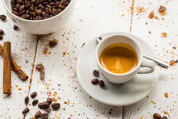 Coffee Cup, Beans, Cinnamon Sticks on White Wooden table