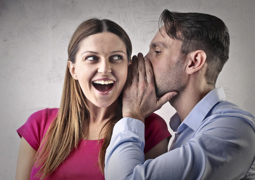 Man whispering a secret to his girlfriend
