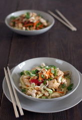 Chicken with noodles and cashew on wooden table