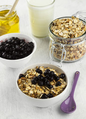 Breakfast: granola, yogurt, honey, blueberry on a white backgrou