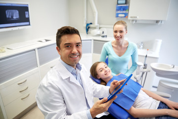dentist with tablet pc, patient girl and mother