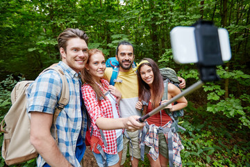 friends with backpack taking selfie by smartphone