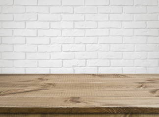 Rough wooden texture table over defocused white brick wall background