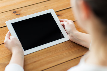 close up of woman with tablet pc on wooden table