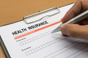 man signing a health insurance policy