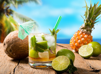 Mojito drink on wood with blur beach background