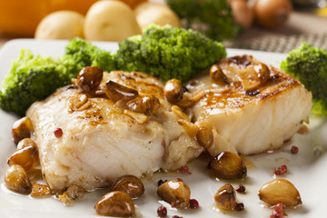 Codfish - fish fillet in sauce with garlic and vegetables