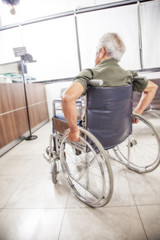 man's arm pushing wheel of wheelchair