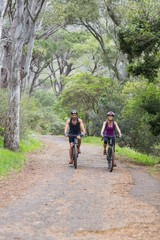 Obraz premium Man and woman riding bike in forest