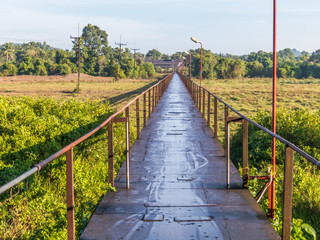 Metal bridge with fields and forest background