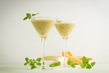 Fresh banana cocktail with mint on the wooden background