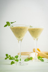 Fresh banana cocktail with mint on the wooden background