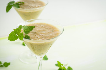 Fresh banana cocktail with mint on the wooden background