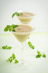 Fresh banana cocktail with mint on the wooden background