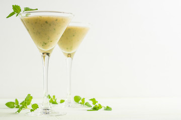 Fresh banana cocktail with mint on the wooden background