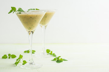 Fresh banana cocktail with mint on the wooden background