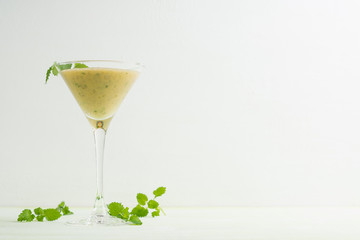 Fresh banana cocktail with mint on the wooden background