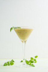 Fresh banana cocktail with mint on the wooden background