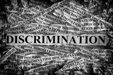 Torn pieces of paper with the word Discrimination