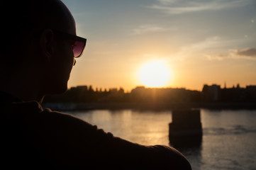 Man silhouette looking over the city in sunset