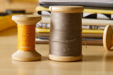 Modern patchwork fabrics in black, brown, white, yellow and grey on the wood table with yellow...