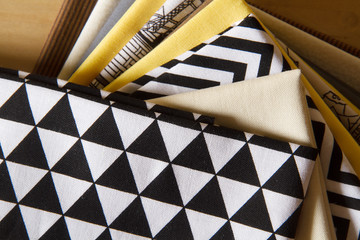 Modern patchwork fabrics in black, brown, white, yellow and grey on the wood table