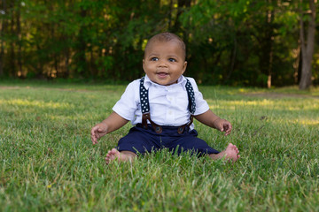 A toddler sitting in the grass