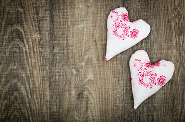 Two fabric hearts on brown wood floor
