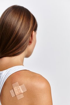 Woman with plaster on back of right shoulder