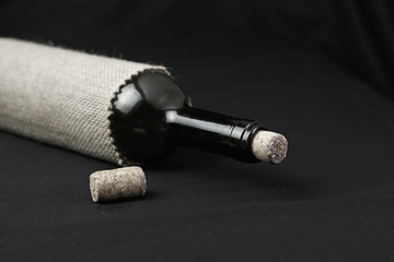 Bottle of wine with cork on black background
