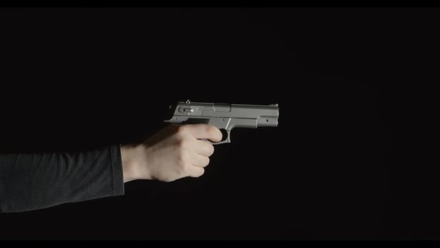 Human hand with a pistol show up in a frame
