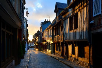 Fototapeta premium Picturesque street in the Normandy town of Honfleur, France with light of the rising sun