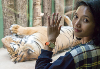 Woman in front of the cage with a tiger