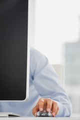 Mid-section of mans hand working on computer