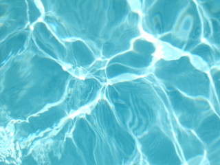 Türkisblaues Wasser in Bewegung mit Spiegelung der Sonne: ein Blick in den Pool