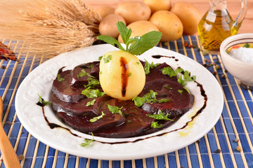 White dish with sliced beetroot and mint