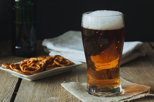 Beer glass and snacks on wooden table