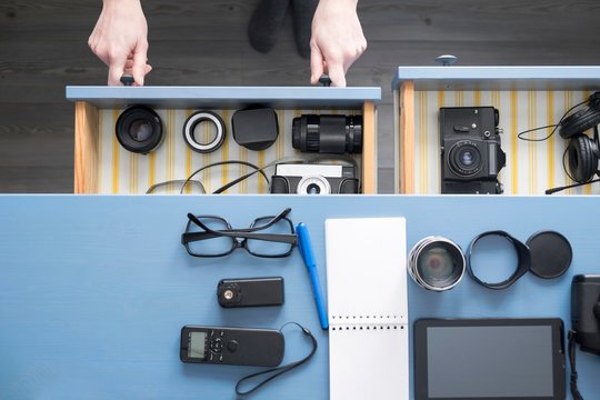 Overhead view of female photographers hands opening desk drawer in studio