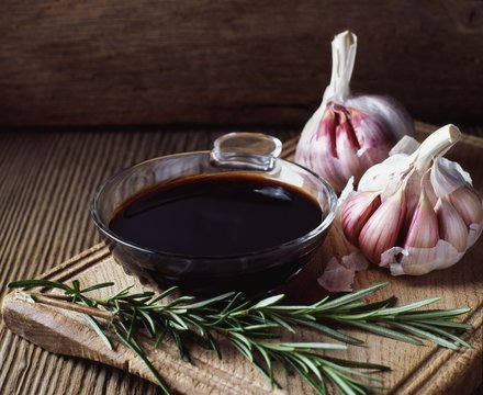 Rosemary, garlic bulbs and bowl of balsamic vinegar