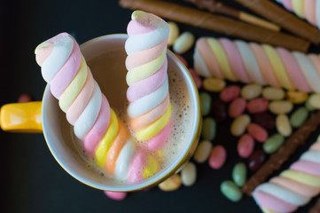 Yellow mug with coffee and twisted marshmallow