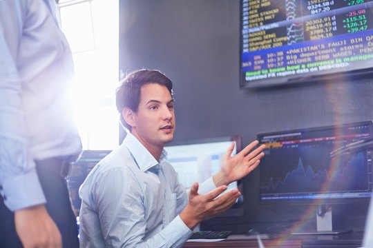 Mid adult business man in office having discussion, hand gestures