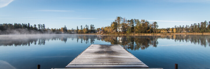 Fototapeta premium Panorama showing quay and reflective lake in winter