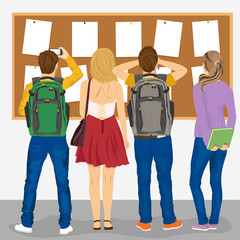 back view of college students looking at bulletin board