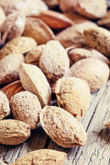 Salted almonds in shell on a vintage wooden background, selectiv
