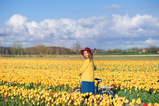 Woman standing with her bike in tulips fields