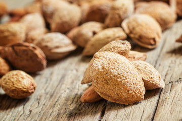 Salted almonds in shell on a vintage wooden background, selectiv