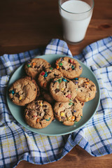 cookies on a plate and a glass of milk on a wooden table