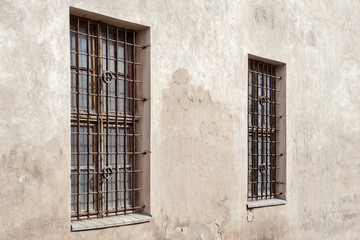 Fototapeta na wymiar abandoned grunge cracked stucco wall with two window grilles