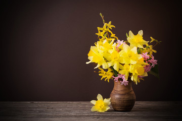 Daffodil in vase on brown background