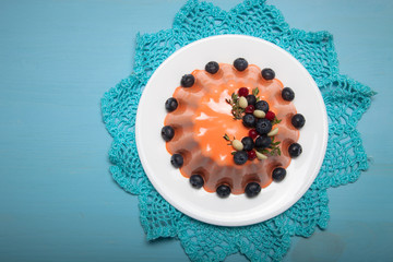 Orange mousse cake with berries n the blue wooden table